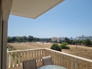 a balcony with a table and chairs and a view of a field at King's Holiday Apartments in Paphos City