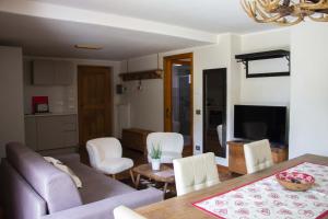 ein Wohnzimmer mit einem Sofa, einem Tisch und Stühlen in der Unterkunft Maison Carrel Elegant 1 in Breuil-Cervinia