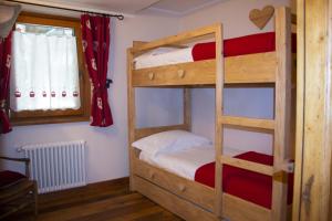 1 Schlafzimmer mit 2 Etagenbetten und einem Fenster in der Unterkunft Maison Carrel Elegant 1 in Breuil-Cervinia