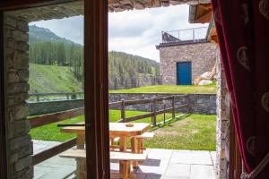 ein Fenster mit Blick auf einen Tisch und Bergblick in der Unterkunft Maison Carrel Elegant 1 in Breuil-Cervinia