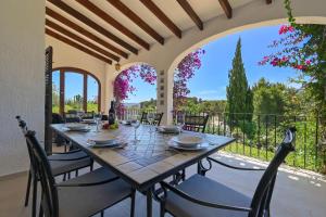 a dining room with a table and chairs and a balcony at Casa Renata in Jávea