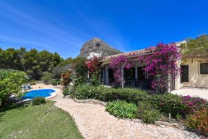 a house with flowers and a swimming pool at Casa Renata in Jávea
