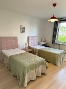Cette chambre comprend 2 lits et une fenêtre. dans l'établissement Mysiga lägenheter i Kalmar centrum, à Kalmar