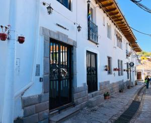 un edificio bianco con porte nere su una strada di Sambleña a Cuzco