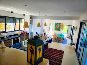 un salon avec une cuisine et une salle à manger dans l'établissement Très belle villa avec piscine et vue incroyable sur mediterannée (DAR NAIM), à Tanger