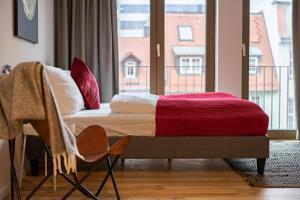 Bett in einem Zimmer mit einem großen Fenster in der Unterkunft Anders Apartments in Jena