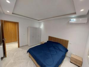 ein Schlafzimmer mit einem Bett mit einer blauen Decke in der Unterkunft حي الواحات in Tunis
