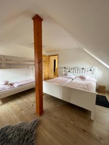 Chaloupka Kunčice في ستاريه ميستو: سريرين بطابقين في غرفة مع أرضيات خشبية