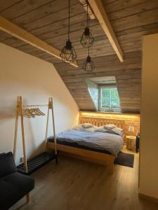 a bedroom with a bed in a room with wooden ceilings at Chaloupka Kunčice in Staré Město