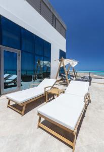 two beds on a patio with the ocean in the background at Tolip Resort Paradise New- Alamein in Marsa Matruh