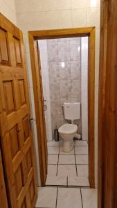 a bathroom with a toilet and a wooden door at Къща за гости Великите in Veliko Tŭrnovo +9 photos