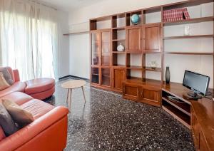 Una sala de estar con un sofá y un televisor. en Appartamento con 7 posti letto, en Albissola Marina