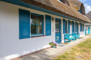 ein Haus mit blauen Fenstern und einer blauen Tür in der Unterkunft Haus Hansi in Wieck