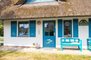 Cottage mit Strohdach und blauer Tür in der Unterkunft Haus Hansi in Wieck