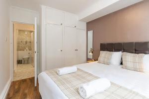 a bedroom with a large bed with two towels on it at Lovely apartment near Hyde Park & Oxford St in London
