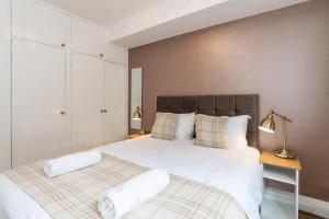 a bedroom with a large bed with two white pillows at Lovely apartment near Hyde Park & Oxford St in London