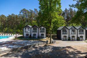 an exterior view of a house with a swimming pool at Gryf Domki Pobierowo in Pobierowo