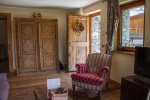 a living room with a chair and a door at Maison Carrel Elegant 2 in Breuil-Cervinia