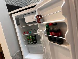 a refrigerator door is open with drinks in it at Hotel APART Zuccolotto 1 in Aracruz