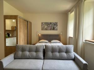 a bedroom with a couch in front of a bed at AMARIT in Dziwnów