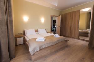 a bedroom with a large bed with two towels on it at Katrin Apartments in Jūrmala