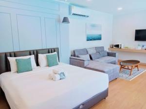 1 dormitorio con 1 cama grande y 1 sofá en La Riva Boutique Hotel, en Kamphaeng Phet