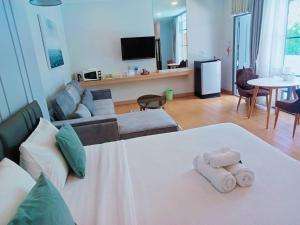 a room with a bed and a living room at La Riva Boutique Hotel in Kamphaeng Phet