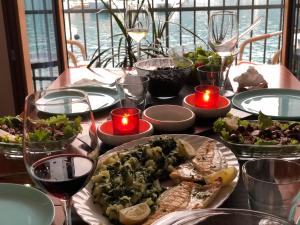 - une table avec des assiettes de nourriture et des verres de vin dans l'établissement Apartments Aleksić Old Town, à Budva