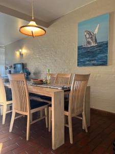 a dining room with a wooden table and chairs at Dolphin View Self Catering in Scottburgh