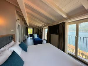 1 dormitorio con cama grande y ventana grande en Villa Clementina Boutique Hotel, en Colonno