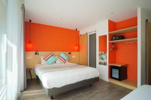 una camera con letto e testiera arancione di La Regence a Courbevoie