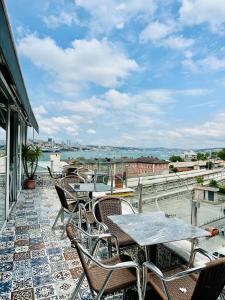 een patio met tafels en stoelen op een dak bij Crowned Plus Hotel in Istanbul