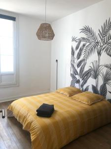 a bedroom with a large bed with a yellow blanket at En hyper centre, Le Saint Aubin in Angers