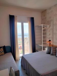 una camera con due letti e una grande finestra di Albergo Aquila a Rimini