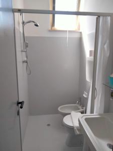 La salle de bains est pourvue d'une douche, de toilettes et d'un lavabo. dans l'établissement Albergo Aquila, à Rimini