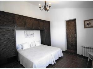 a bedroom with a large bed with a wooden headboard at Belvilla by OYO Casa Almendro in La Joya