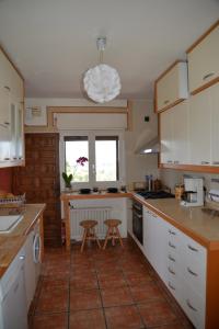 a kitchen with white cabinets and a table and chairs at LA CASA DE GALAPAGAR ALOJAMIENTO SIETE PICOS in Galapagar