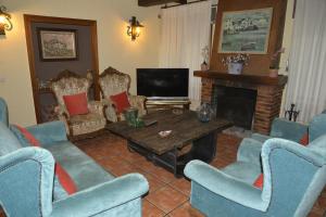 a living room with blue chairs and a fireplace at LA CASA DE GALAPAGAR ALOJAMIENTO SIETE PICOS in Galapagar
