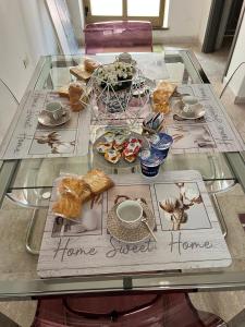 een glazen tafel met een home sweet home bord erop bij The mistral in Scilla