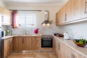 a kitchen with wooden cabinets and a bowl of fruit on the counter at Villa Georgia in Lefkímmi