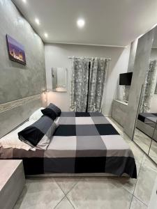 una camera con un grande letto bianco e nero di Casa Ferdinandea a Catania