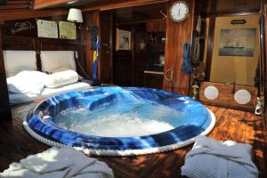 a large blue tub in a room with a bed at Bonavia B&B in Sistiana