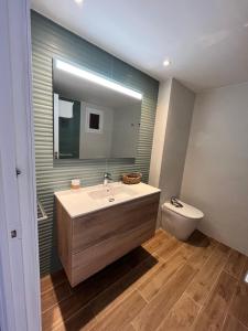 a bathroom with a sink and a mirror and a toilet at Apartamento en Costamar I, 2ª Planta, 23 in Es Pujols