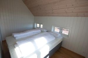 a large white bed in a room with a window at Day Dream Hellnar in Snæfellsbær