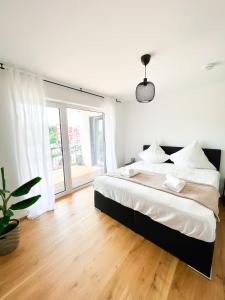 a bedroom with a large bed and a large window at theSunset Club - SUITE L Balkon - Küche - Parkplatz in Memmingen
