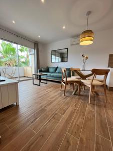 a living room with a table and chairs and a couch at Apartamento en Costamar I, 2ª Planta, 23 in Es Pujols