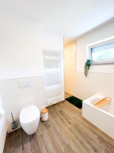 a bathroom with a toilet and a sink and a tub at theSunset Club - SUITE L Balkon - Küche - Parkplatz in Memmingen