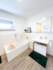 a white bathroom with a tub and a sink at Sunset Club - SUITE L Balkon - Küche - Parkplatz in Memmingen