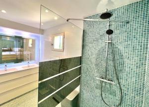 Łazienka z prysznicem wyłożona jest zielonymi kafelkami. w obiekcie Villa La Source 83 - room close to St Tropez w mieście Cogolin