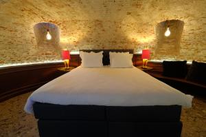 Secret Jacuzzi Mons - Parking privé gratuit في مون: غرفة نوم بسرير ابيض كبير ومصباحين